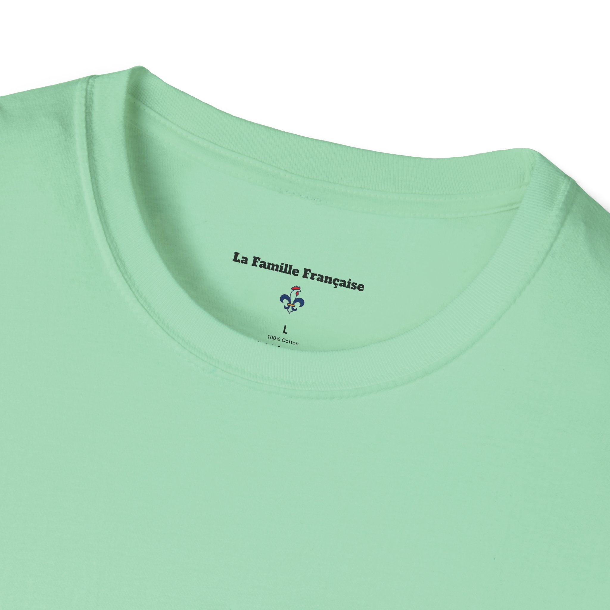 T-shirt La Famille Française vert menthe – logo coq tricolore côté cœur et dos inscription noire humoristique “J'la mets à gauche sauf quand on parle politique”. 